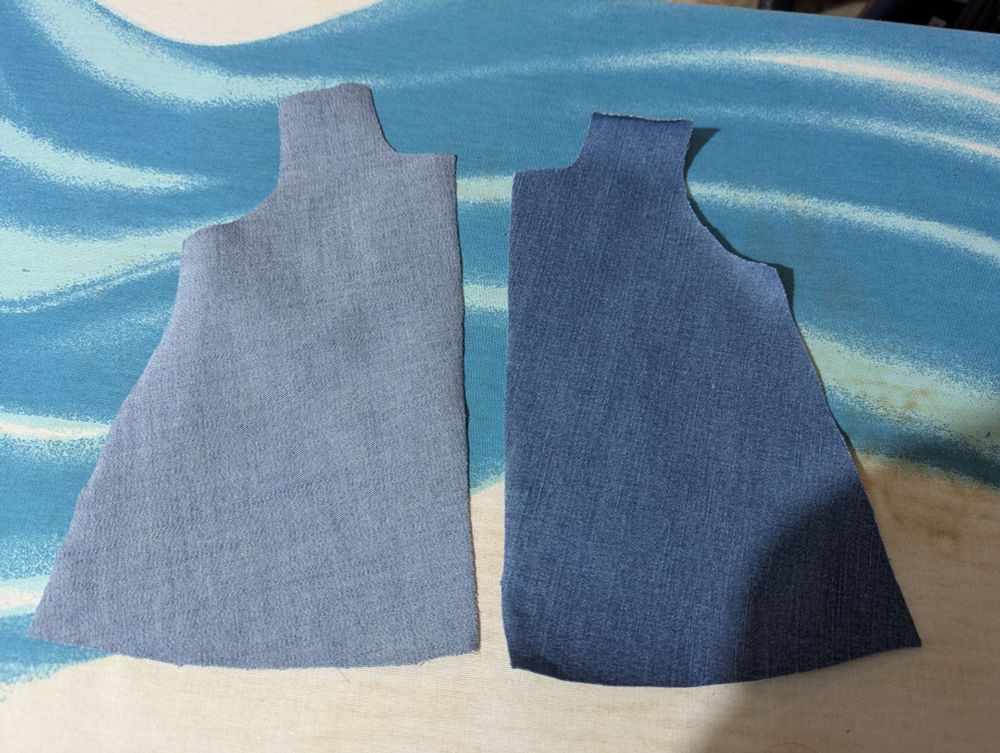 Two pattern pieces for a doll-sized coat face each other. One shows the correct side facing out; the other, the very obviously wrong side.
