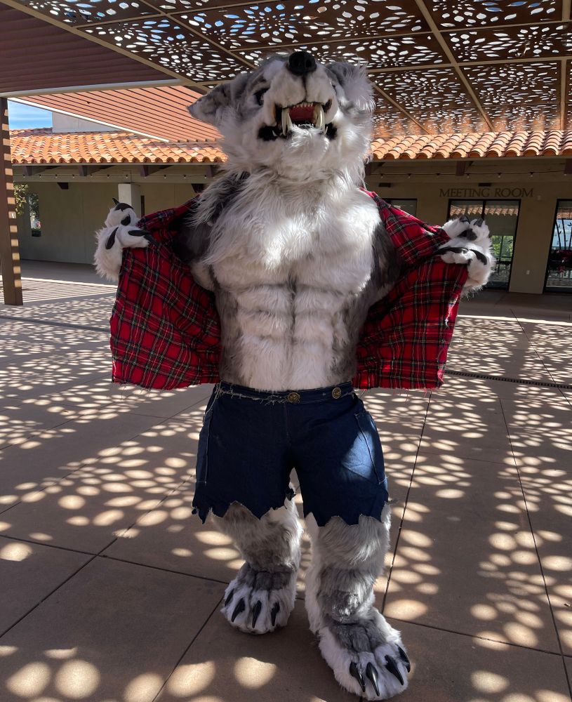 An unhinged werewolf named Cray pulls his flannel shirt open while lifting his head high up to howl.