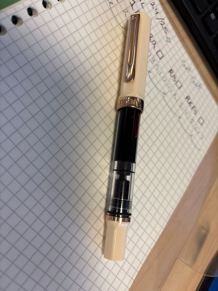 Cream, rose-gold TWSBI Eco sitting on a planner.