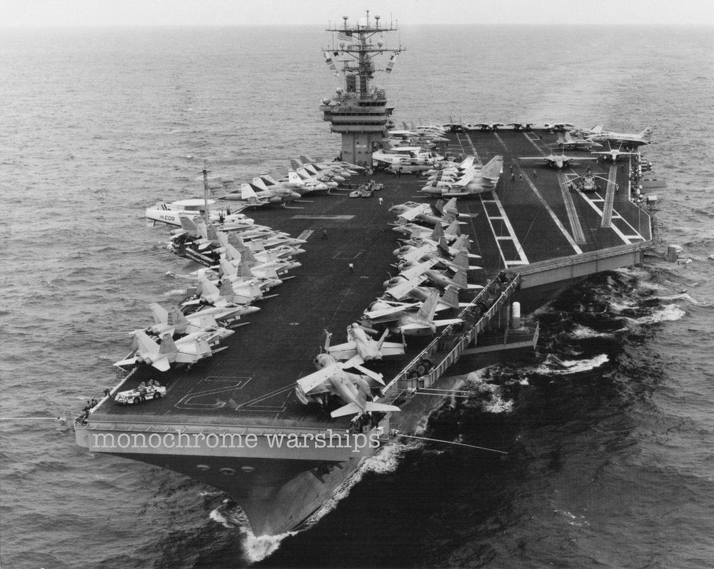 Nimitz-class carrier Abraham Lincoln doing what it does best by lugging a shit-load of aircraft around. The flight deck is packed with parked aircraft. I can see Hawkeyes, Prowlers, F-14s, F-18s, Vikings, and Sea Hawks. Any other spots? 