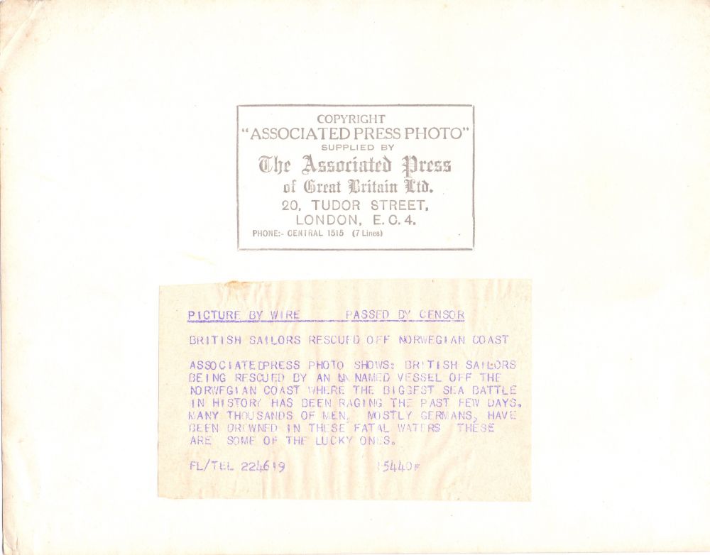 Rear of photo with 'Copyright Associated Press Photo' stamp. Also has the following somewhat dramatic and remarkably short on facts press release stuck to it:
"Picture by wire - Passed by censors
British sailors rescued off Norwegian coast.
Associated Press photo shows: British sailors being rescued by an unnamed vessel off the Norwegian coast where the biggest sea battle in history has been raging the past few days. Many thousands of men, mostly Germans, have been drowned in the fatal waters. These are some of the lucky ones."
