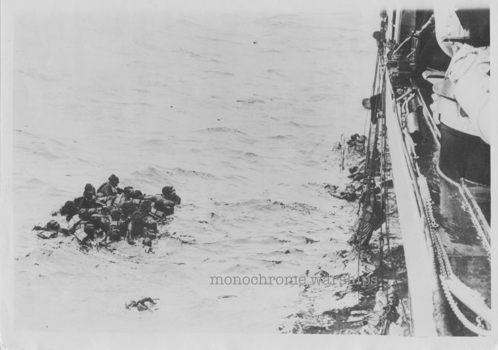 Oil-soaked crew from HMS Glowworm cling to debris close to the side of the Hipper. Ropes hang down from Hipper's deck where her crew are pulling survivors aboard. Photo taken from aboard the Hipper.