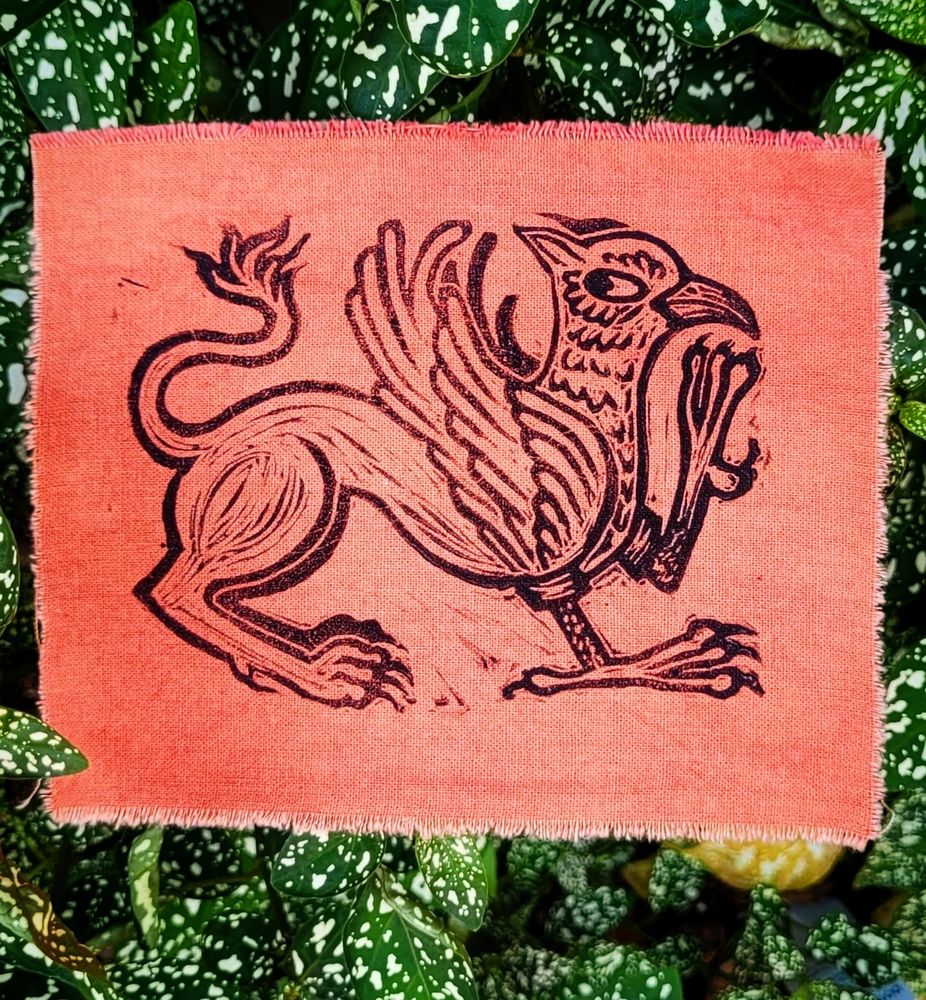 Black gryphon block print on deep orange madder dyed cotton
