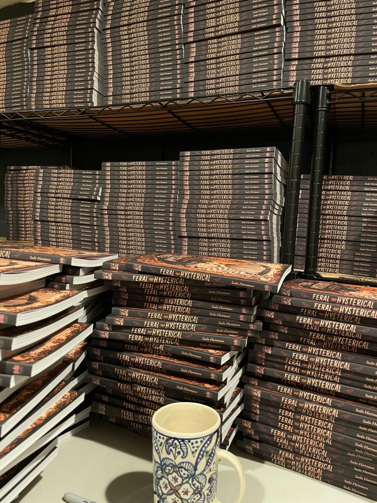 Huge stacks of books, a mug of tea, and a sharpie