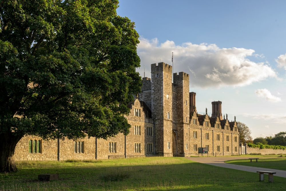 A modern photo of the exterior of Knole, a large manor house with towers.
