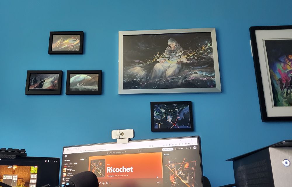 Art prints hanging on a wall above a pc monitor. Most by shmz042