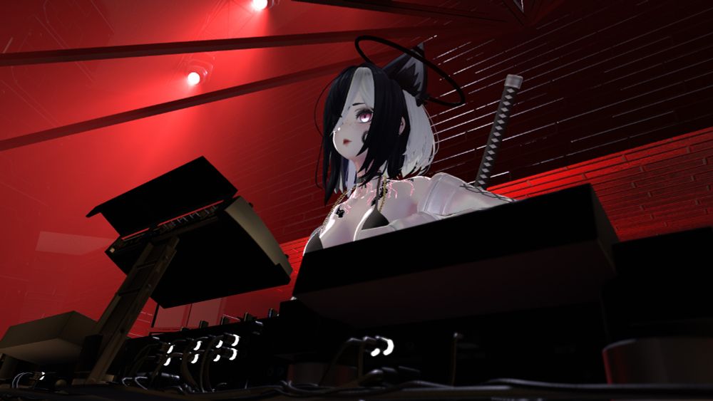 TheVMP behind DJ decks, shot from a low side angle so you can see the deck cables. Their sword and black halo are framed by some diffuse red spotlights in the high corner.