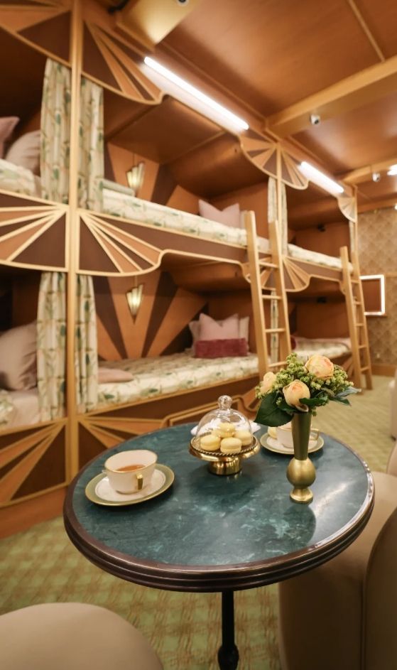 Clean BB27 train room w bunk beds & round table w tea setting.