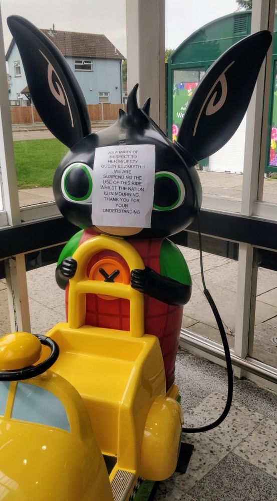 A picture of a Bing bunny ride along toy in a shop with a note posted on it saying as a mark of respect to her her majesty queen Elizabeth II we are suspending the use of this ride whilst the nation is in morning. Thank you for your understanding. 