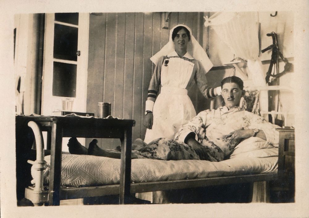 Sister Elsie Russell in her uniform standing next to a hospital bed on which is a British soldier - they are in Ras-el-Tin British Military Hospital, in Alexandria, Egypt during the First World War (Photo courtesy of Stuart James)
