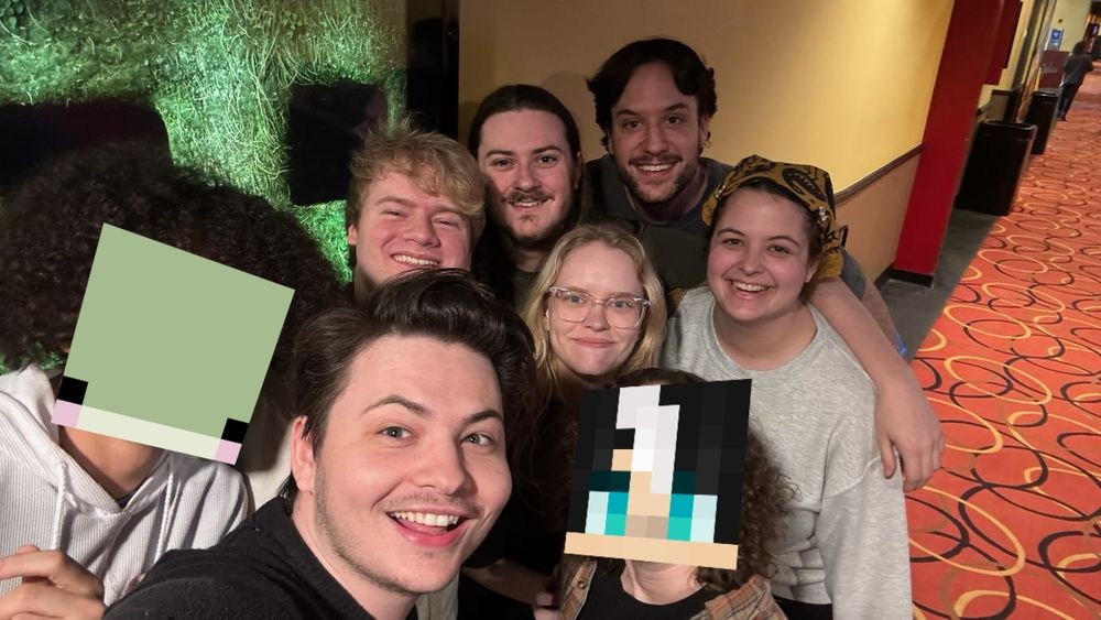 Group photo of Apollotv, JustJeiHere, Zhaakar, Wispyyyz, Shaqcutie, ImLvkas, EthRocky, & Friskini in front of a poster of A Minecraft Movie