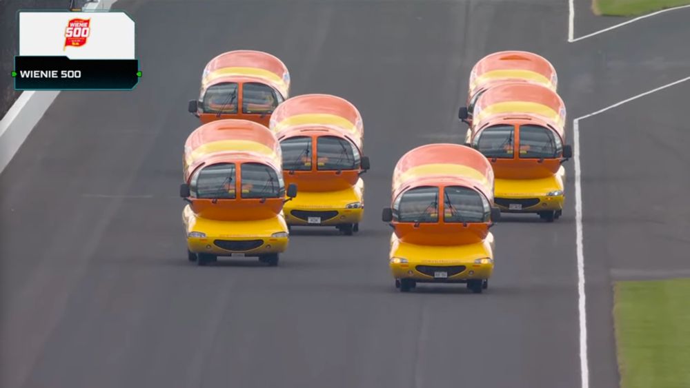 six wienermobiles racing at indianapolis motor speedway for the wienie 500