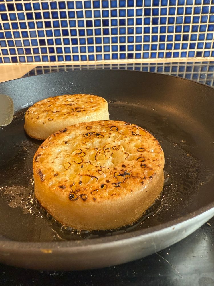 golden buttery crumpets in a frying pan 