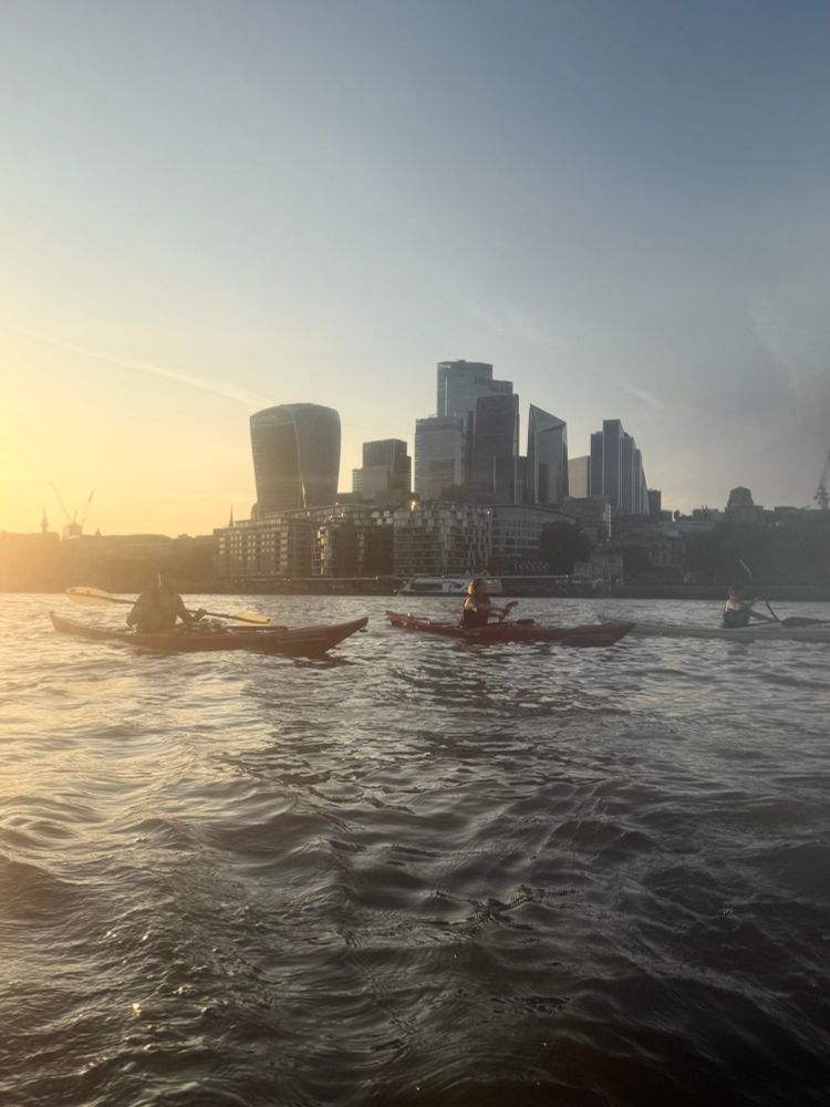 the city looms behind my friends in kayaks on the Thames. The sunset glows to the west 