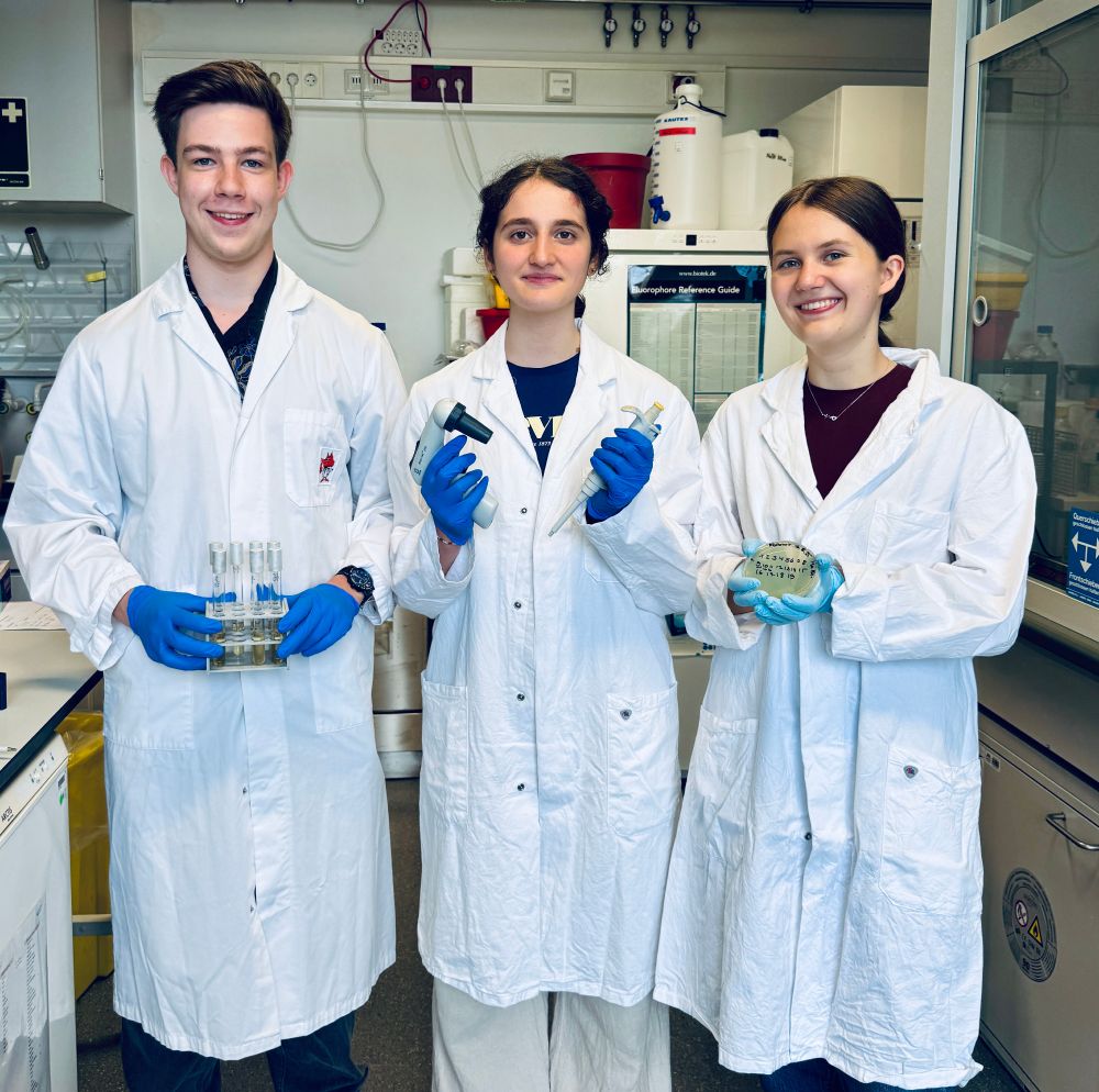 Katharina, Grace and Jonathan holding lab equipment in the Signalling Factory and Robotics lab.