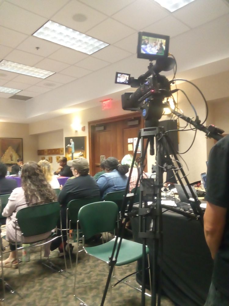 A videocamera records the board meeting for online distribution.