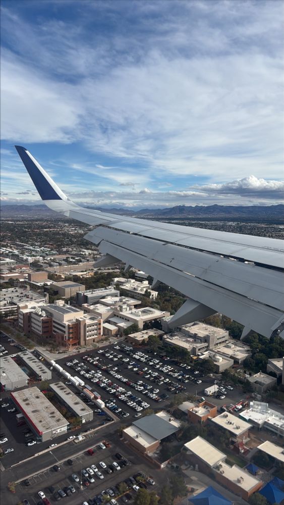 View of airplane wing approaching airport 
