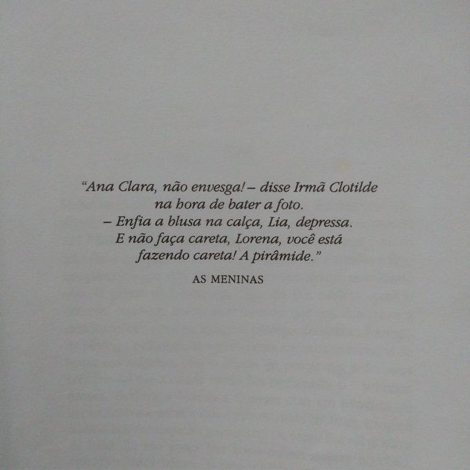 Foto de uma das páginas do livro, onde é possível ler, centralizado na folha, o seguinte: "Ana Clara, não envesga! — disse Irmã Clotilde na hora de bater a foto. — Enfia a blusa na calça, Lia, depressa. E não faz careta, Lorena, você está fazendo careta! A pirâmide." AS MENINAS
