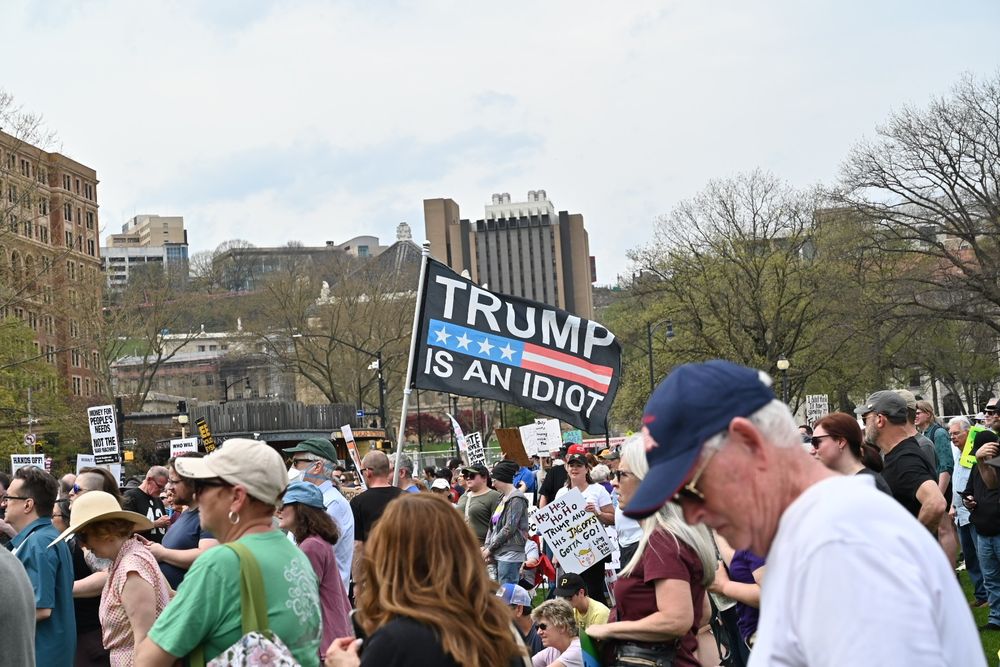 Pittsburgh Protest, people with signs and a large flag with the words "Trump is an idiot"