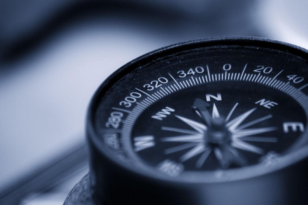 Das Bild zeigt einen Kompass, der symbolisch für die Orientierung im Kostenmonitoring und zu Fördermitteln sowie die zielgerichtete Steuerung steht, indem er den Weg zu finanzieller Stabilität und effizientem Ressourceneinsatz weist.
Im Zentrum des Bildes ist ein Kompass, dessen Nadel Richtung Nord zeigt. Der Kompass ist mit detaillierten Markierungen versehen, die die Grade anzeigen. Der Hintergrund ist blau und unscharf, was den Fokus auf die Kompassnadel verstärkt und die Idee der Richtung und Orientierung in finanziellen Angelegenheiten unterstreicht.