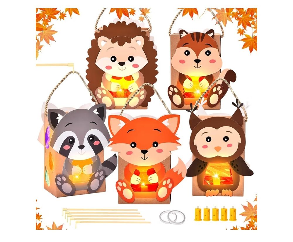 Ein Gruppenbild von fünf herbstlichen Tierlaternen-Bastelsets. Die Laternen sind in Form von Waldtieren gestaltet: ein Igel, ein Eichhörnchen, ein Waschbär, ein Fuchs und eine Eule. Jede Laterne hat ein freundliches, lächelndes Gesicht und die Tiere sitzen auf dem vorderen transparenten oder hellen Teil der rechteckigen Laterne, in deren Inneren ein warm leuchtender LED-Teelicht-Einsatz zu sehen ist, der einen sanften Schein durch die Laterne wirft. Die Laternen sind mit Hanfschnüren zum Aufhängen versehen. Unter den Laternen liegen fünf kleine LED-Lichter, fünf Holzdübel oder -stäbe und zwei silberne Ringe, die zum Zusammenbau der Laternen gehören. Das gesamte Bild ist mit orange-gelben Herbstblättern, hauptsächlich Ahornblättern, umrahmt, um eine herbstliche Stimmung zu erzeugen.