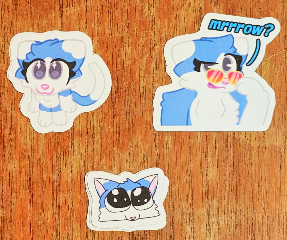 small magnets of Jetta, a blue cat, on a woodgrain background 