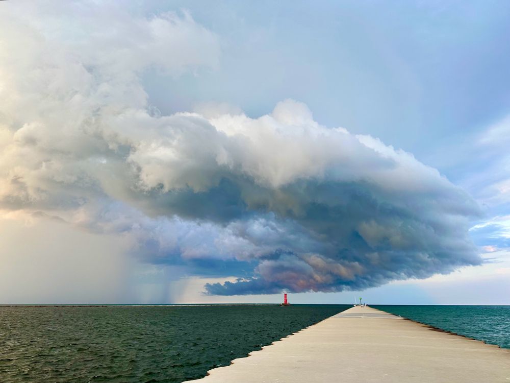 Big storm cloud with rain over iconic Sheboygan, WI lighthouse, south pier. 