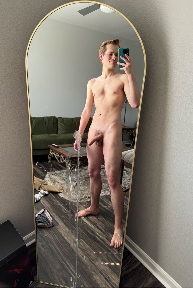 me taking a full length mirror nude selfie after cumming over a large length of the mirror. 