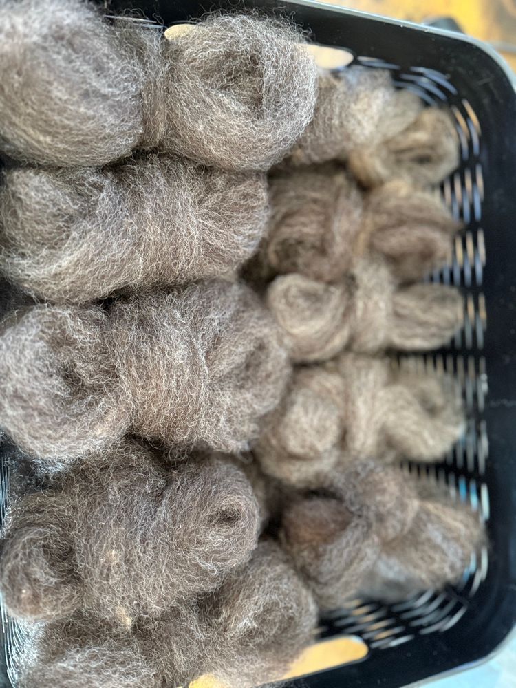 Several little clusters of processed wool in a basket. 