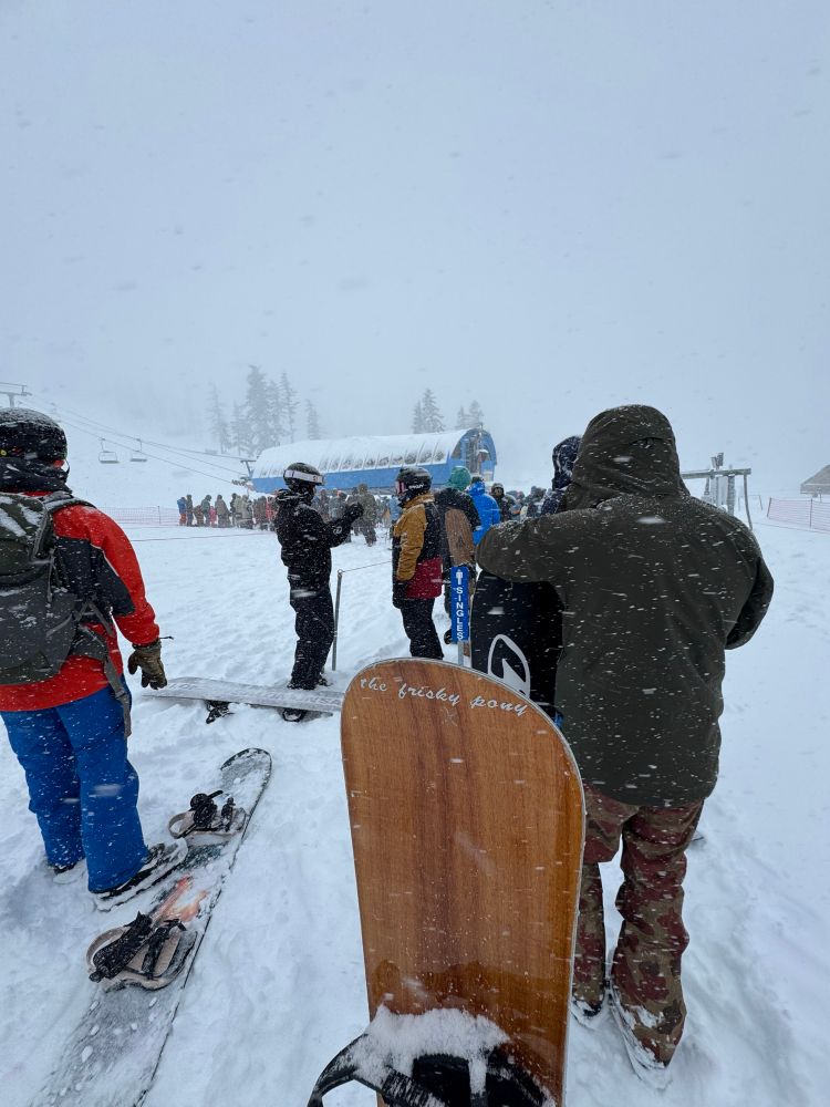 Snowboarder waits in for first chair