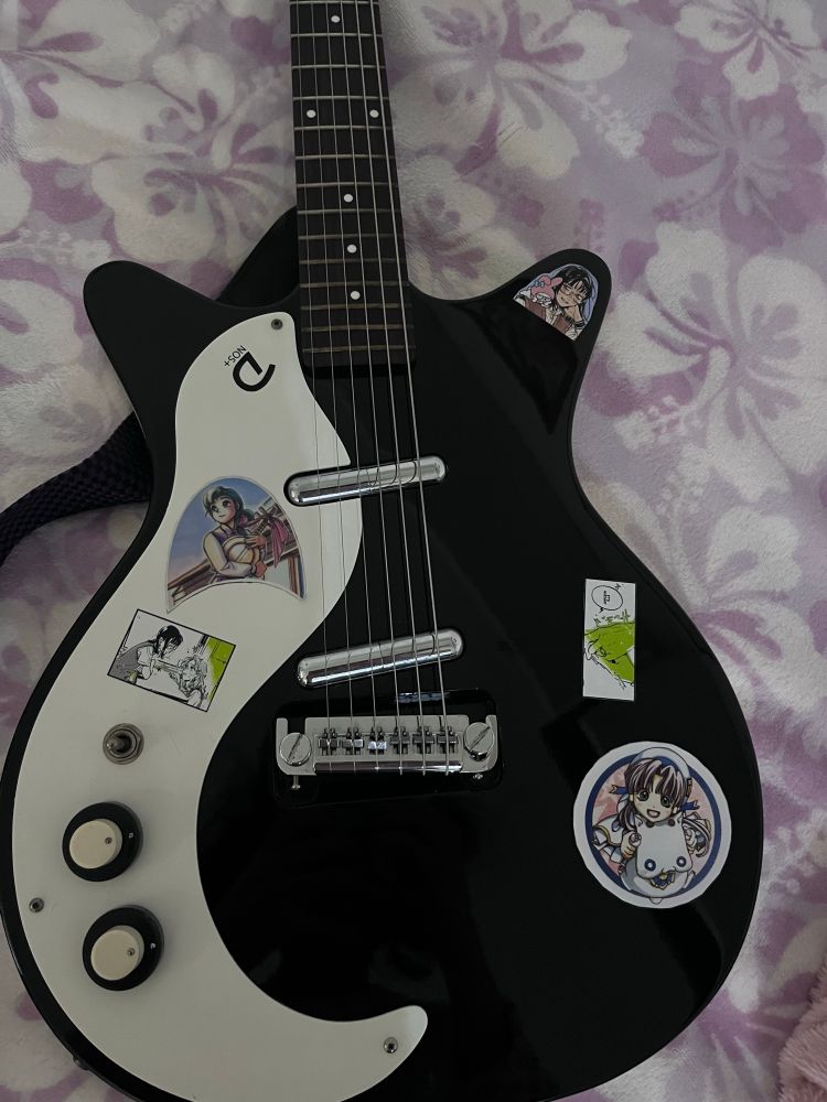 Danelectro Left handed guitar with a bunch of stickers