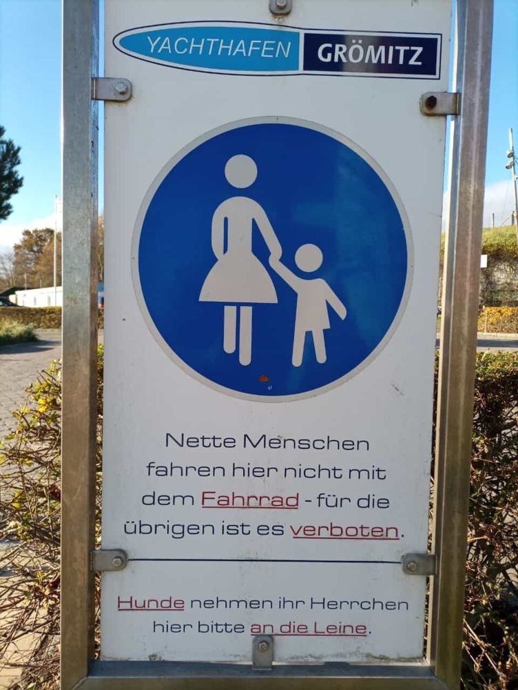Auf einem Schild am Eingang zum Yachthafen von Grömitz steht unter einem Fußgänger-Zeichen: "Nette Menschen fahren hier nicht mit dem Fahrrad - für die übrigen ist es verboten."