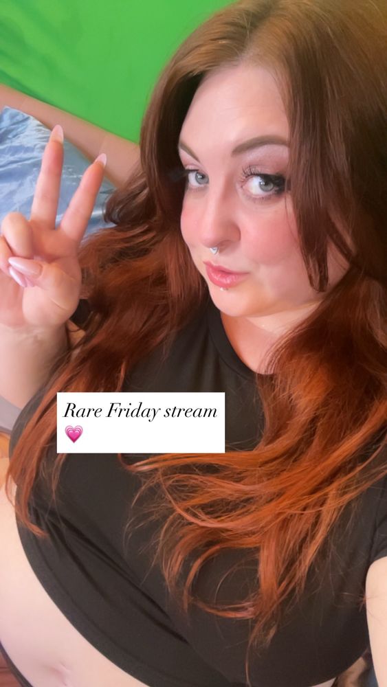 Selfie of Lilith Bunny in a black crop top giving a peace sign. 