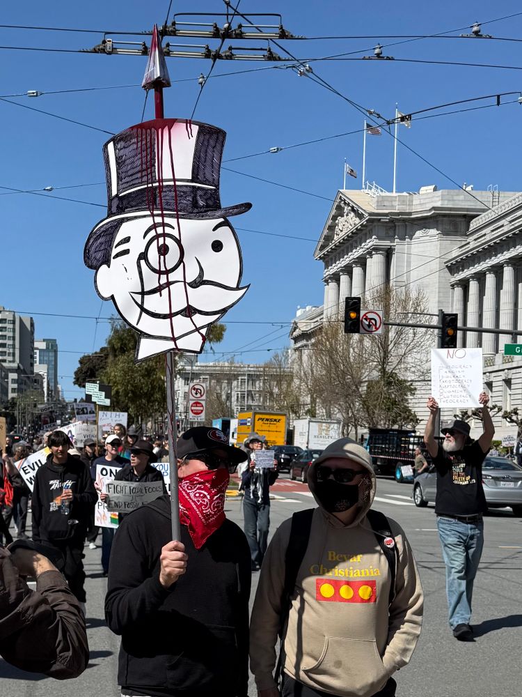 Protestors marching in SF one carrying the monopoly man’s head on a pike