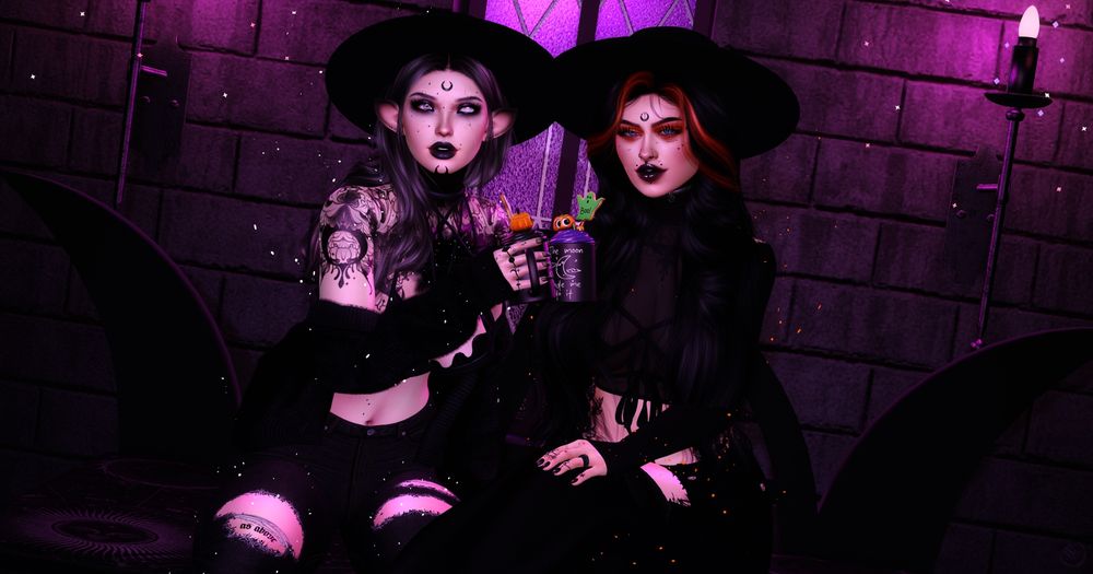 A virtual photo of two people dressed all in black with wide-brimmed hats sitting on a triple moon themed bench. They hold similar mugs of cocoa with a pumpkin and a ghost on a stick topping each.