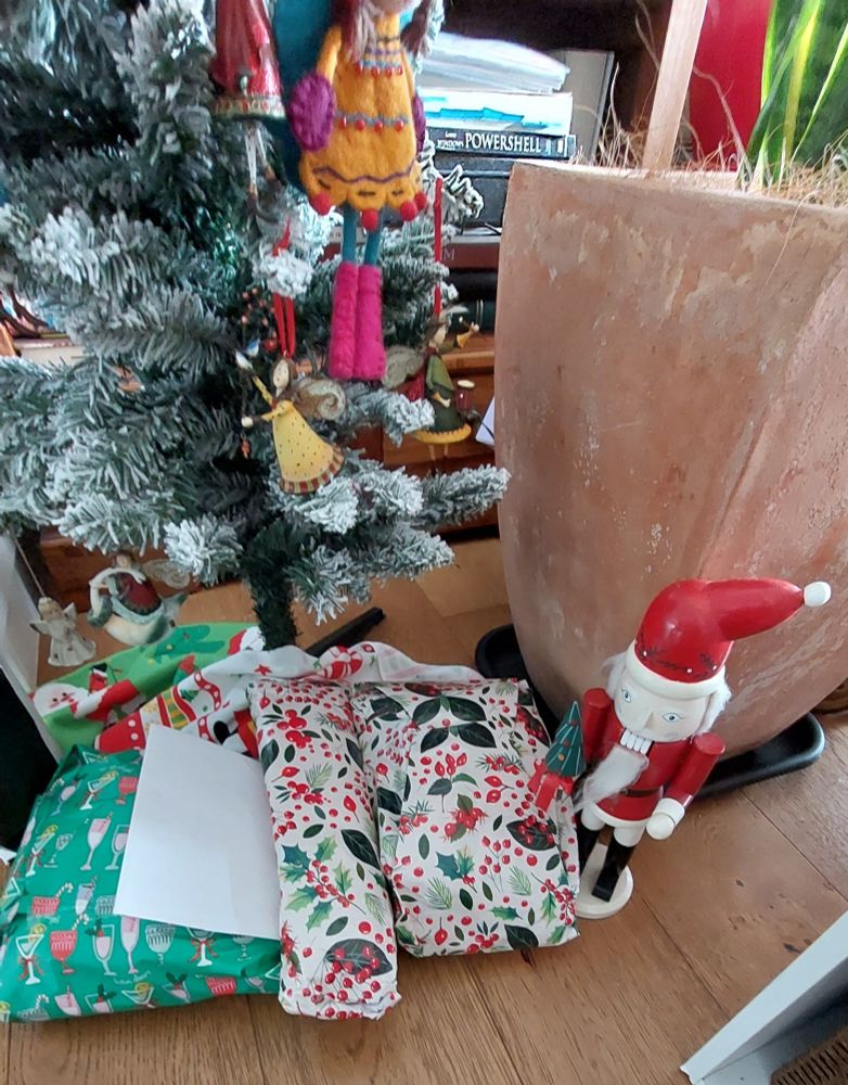 Presents under a Christmas tree with a nutcracker next to them