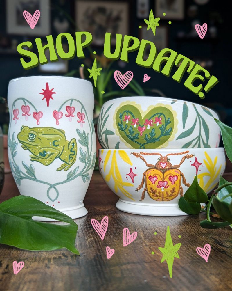 Porcelain bowls stacked together with beetle, heart and bleeding heart flower designs in green, yellow and pink. Next to it sits a porcelain cup with a green frog framed by bleeding heart flowers. Arches text above them says "Shop Update!" in bubbly green lettering. 