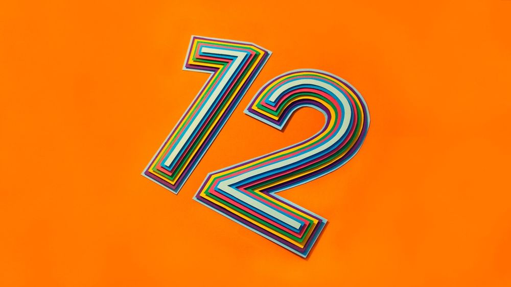 A colourful number 12 on an orange background.
