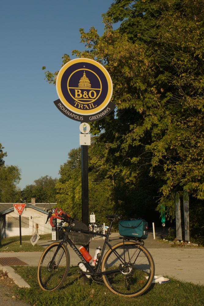 Bicycle leaning against the sign at the eastern trailhead for the B&O trail in Indianapolis 