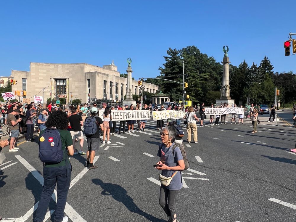 Protesters holding banners block traffic at Brooklyn’s Grand Army Plaza.