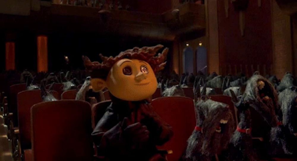 a cartoon character stands in front of a row of dogs in a theater