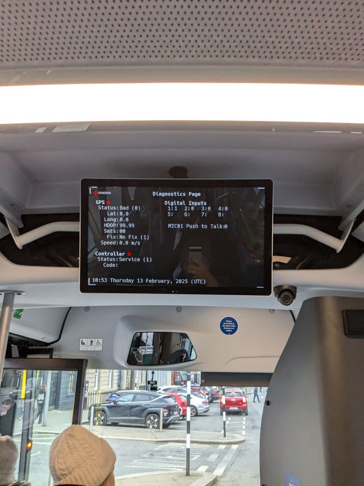 An error screen on a bus information display. Cars and an urban road can be seen in the background through the bus windscreen.