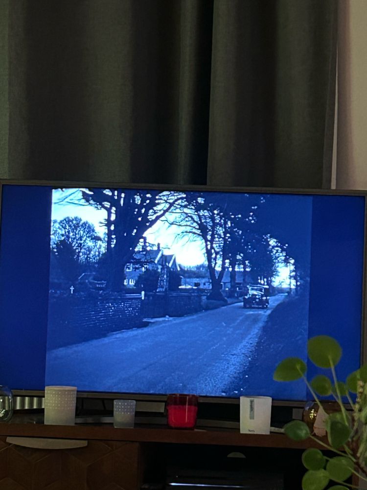 A photo of my tv. I’m watching a black and white film in which an old fashioned car is arriving in a village.