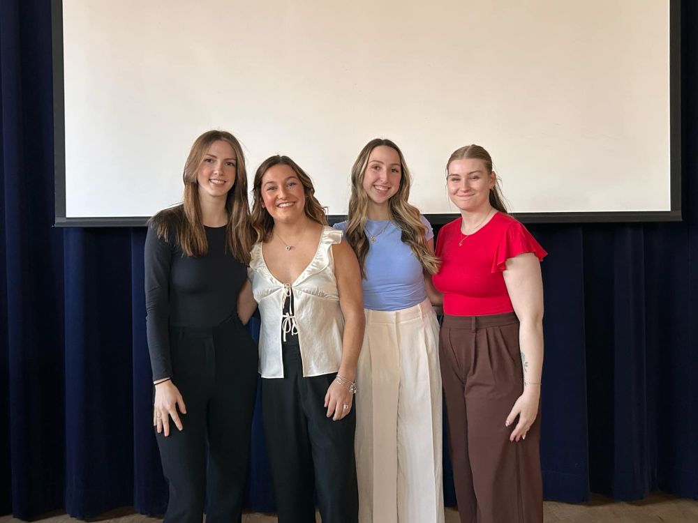 Four smiling undergrads who just finished thesis presentations: Renee Papp, Payton Erwin, Grace Still, and Ciara Wainwright