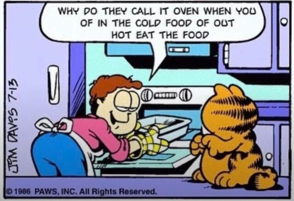 A comic panel from Garfield. It features Jon leaning over to grab a tray of food (presumably lasagna), with his head turned facing Garfield's direction to speak to him. Jon says, "Why do they call it oven when you of in the cold food of out hot eat the food"