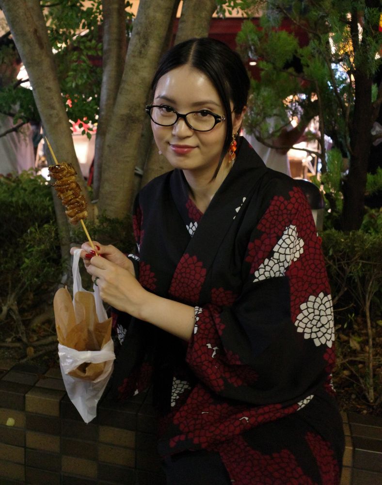 photo of me holding a grilled chicken skin skewer 
