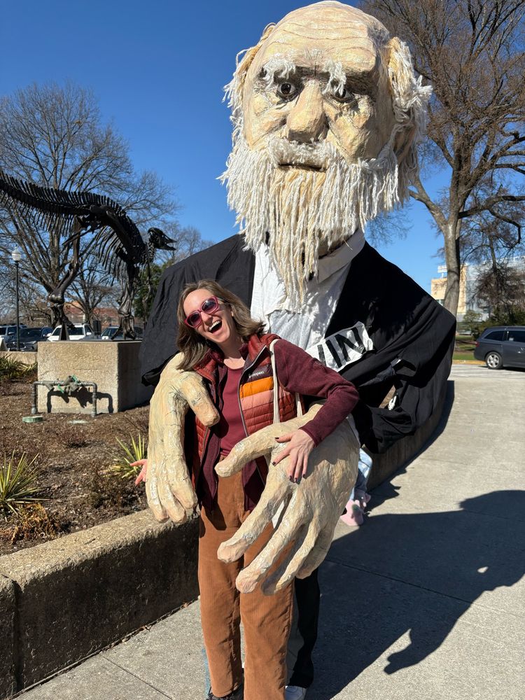 Photo of Sara being prom hugged by a giant paper mache Darwin 