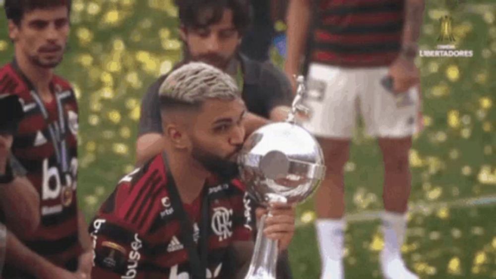 a soccer player is kissing a trophy while wearing a jersey that says ' br ' on it