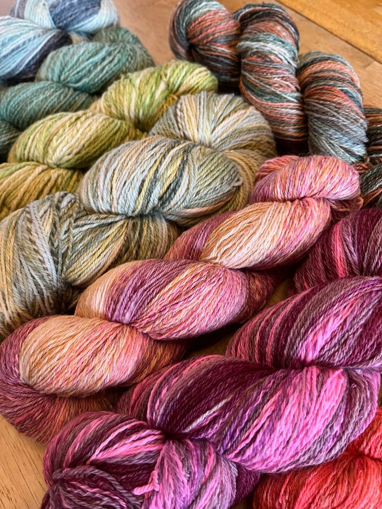 An angled shot of the eight skeins of handspun yarn.