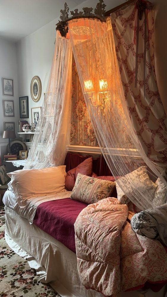 My bed in the house. A bed enclosed in drapes and piled with cushions. 